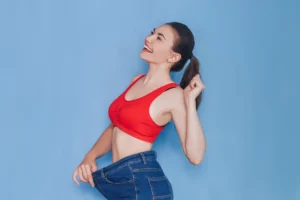 Woman holding up loose jeans to show weight loss after medical weight loss treatment